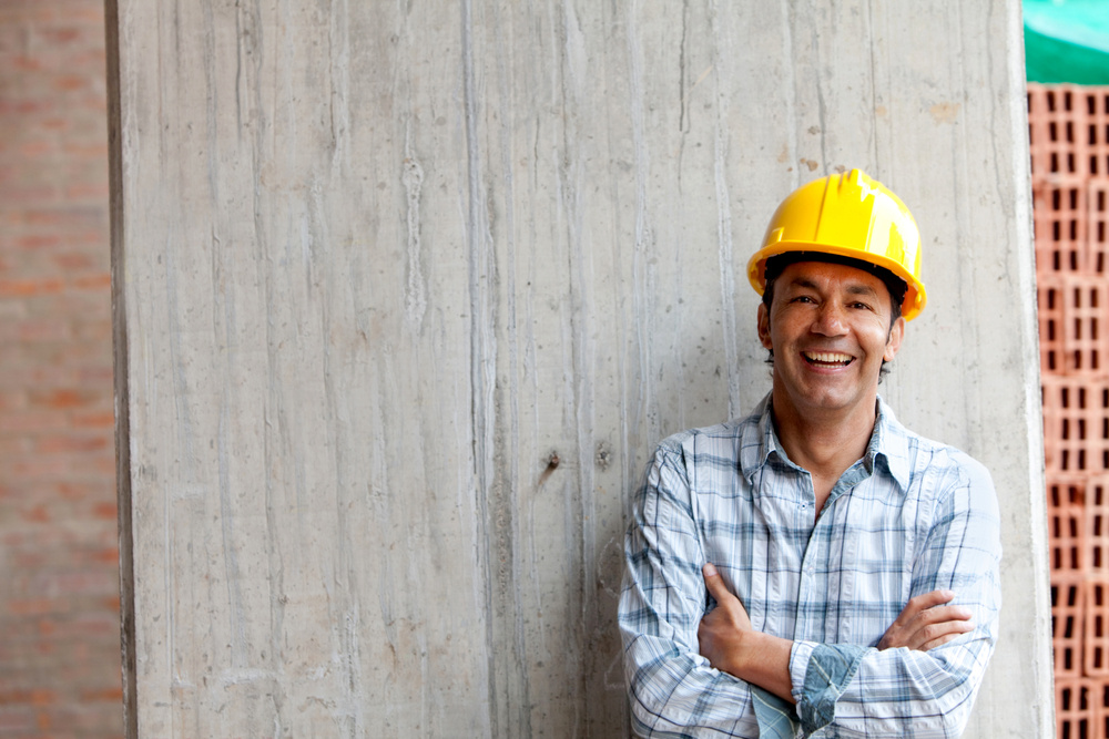 Male construction worker at a building site smiling